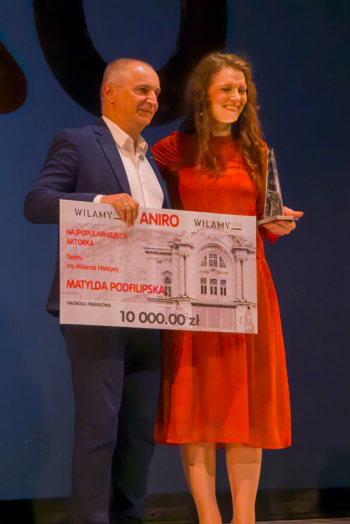 Daniel Kaczmarczyk i Matylda Podfilipska uśmiechają się, pozując z symbolicznym czekiem na 10 000 zł i statuetką na Gali Wilamów 2025.